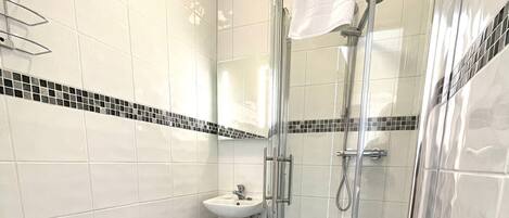 A modern bathroom with a toilet, sink, and glass-enclosed shower.