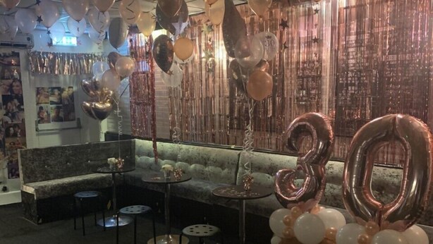 A room with a sofa, round tables, and a large number '30' balloon decoration. - The Butterfly Hotel - Group Weekends (Blackpool)