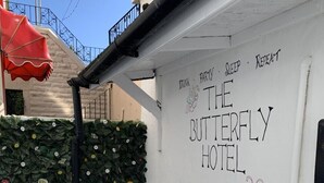 A white exterior wall with the text "THE BUTTERFLY HOTEL" and a butterfly drawing. - The Butterfly Hotel - Group Weekends (Blackpool)