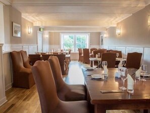 A spacious dining area with high-backed chairs and long tables, well-lit by wall-mounted lamps. - The Linton Hotel (East Linton)
