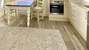 A kitchen with a window, a chandelier, and a built-in oven. - The Mount Somerton (Somerton)