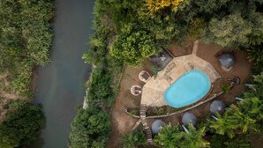 An aerial view of a private pool area surrounded by dense greenery, with a clear pool and stone pathways. - Karongwe - Chisomo Safari Camp (Tzaneen)