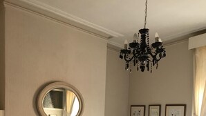 A bedroom with two beds, a chandelier, a mirror, and framed pictures on the wall. - Albemarle Hotel (Scarborough)