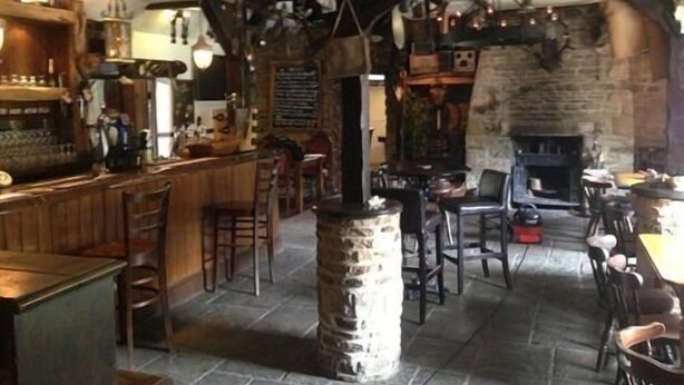 A rustic pub interior with exposed beams, stone walls, and a bar area. - The Old Mill Knitsley (Consett)