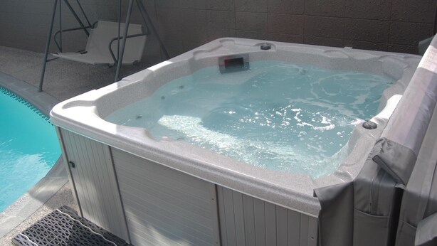A hot tub with a view of a swimming pool. - Rotorua Motel (Rotorua)