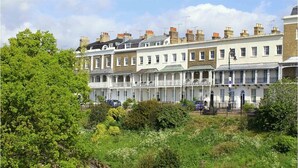 A row of terraced houses with a garden in the foreground.