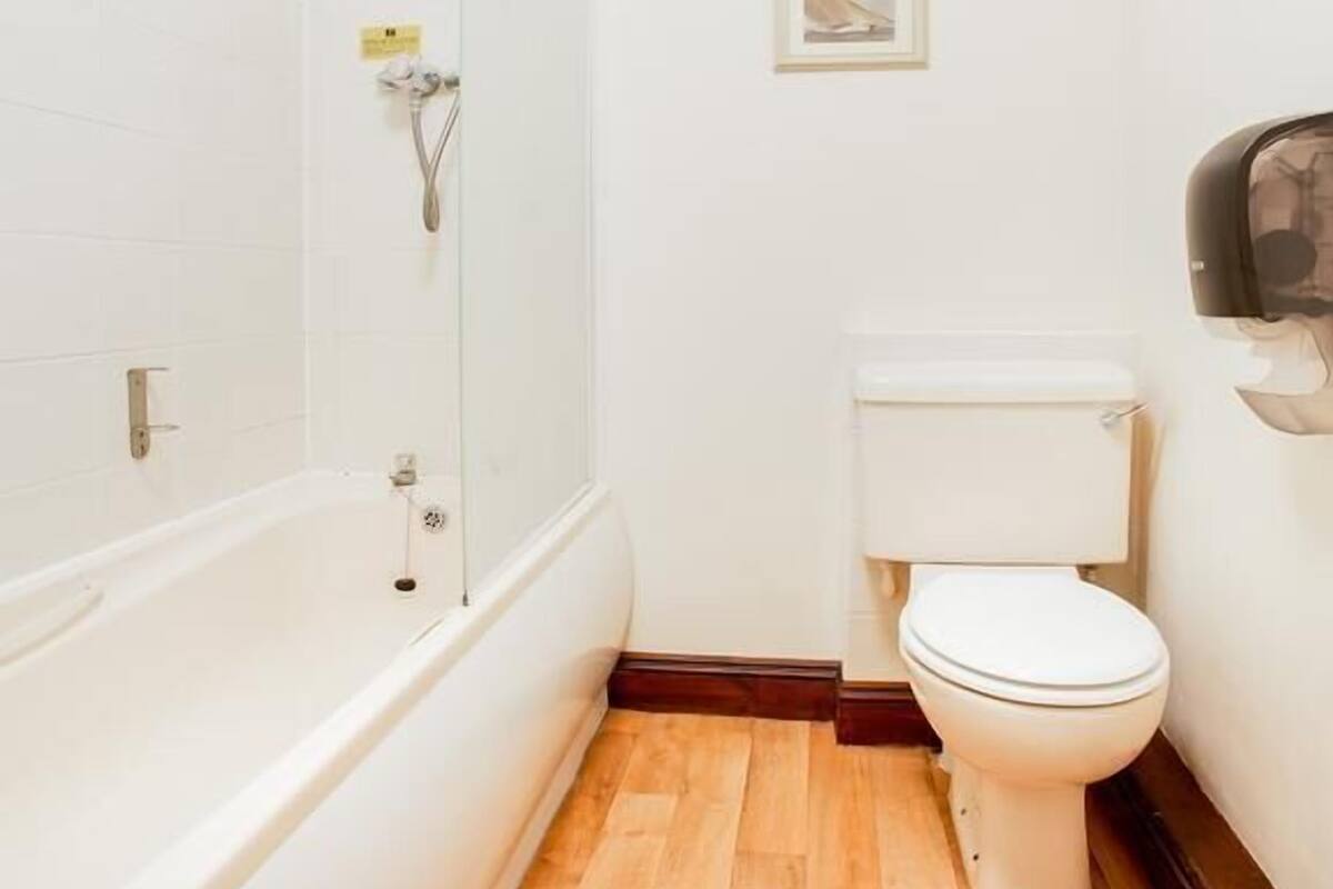 A bathroom with a bathtub, toilet, and shower.