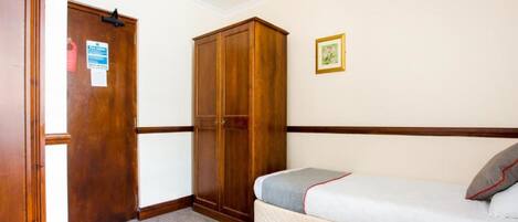 A bedroom with a bed, a wardrobe, and a door.