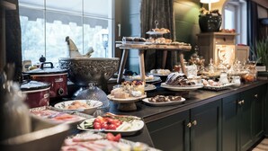 A buffet with various dishes and a large decorative bowl.