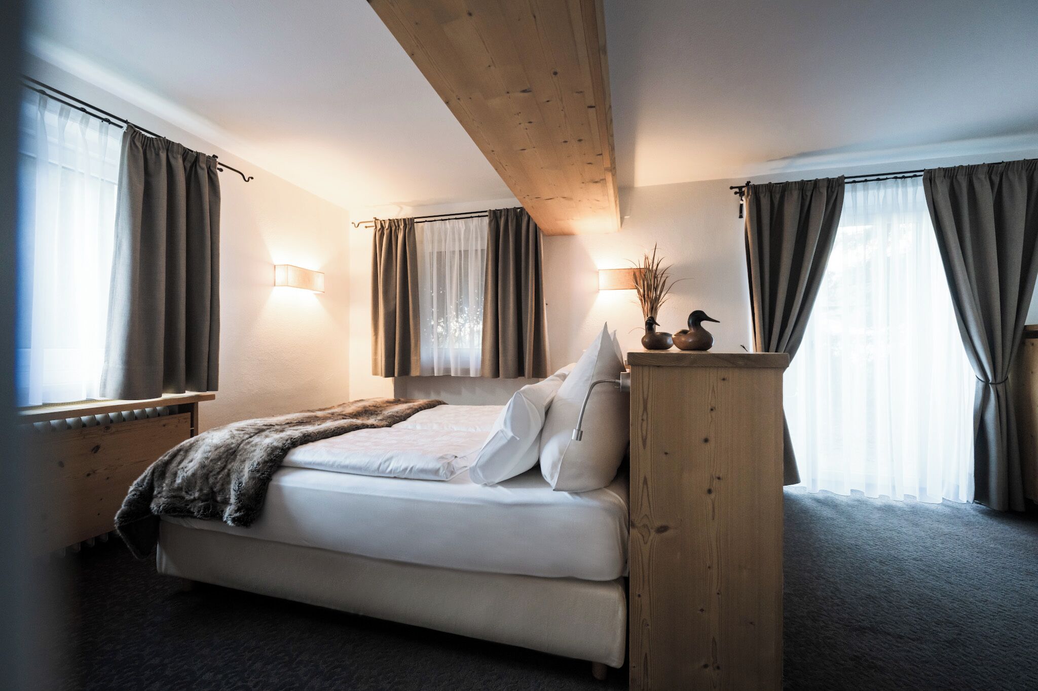 Een slaapkamer met een bed, houten hoofdbord, nachtkastjes en een nachtkast.
