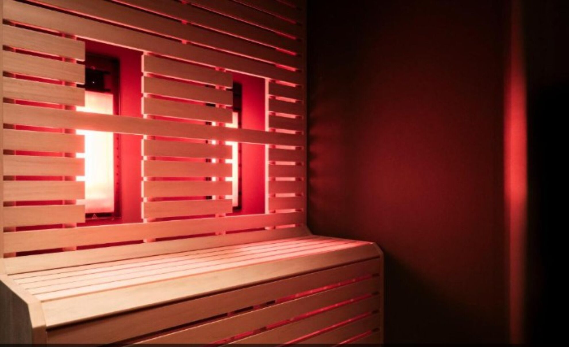 Una habitación con un banco de madera y una pared con listones horizontales.