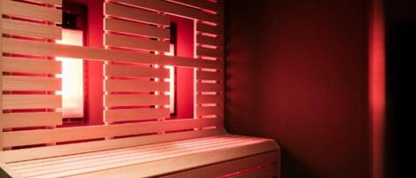 A room with a wooden bench and a wall with horizontal slats.
