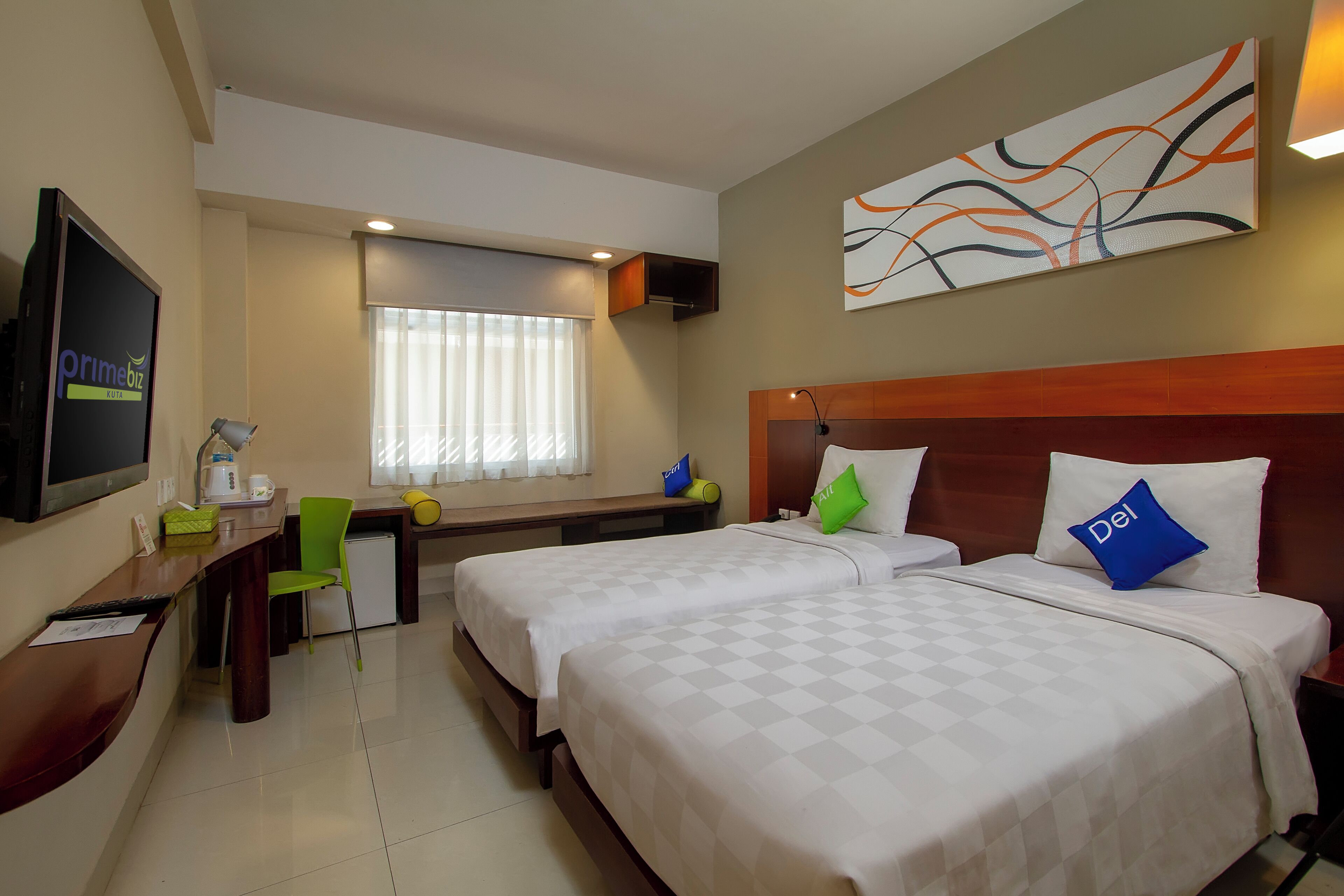 Habitación de hotel con dos camas, un escritorio, una silla, un televisor y una ventana con cortinas.