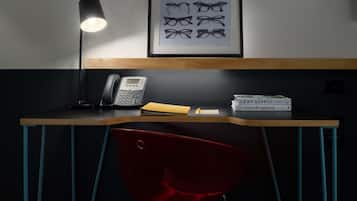 A desk with a telephone, a framed picture of glasses, and a box labeled "LEAF SUPPLY".