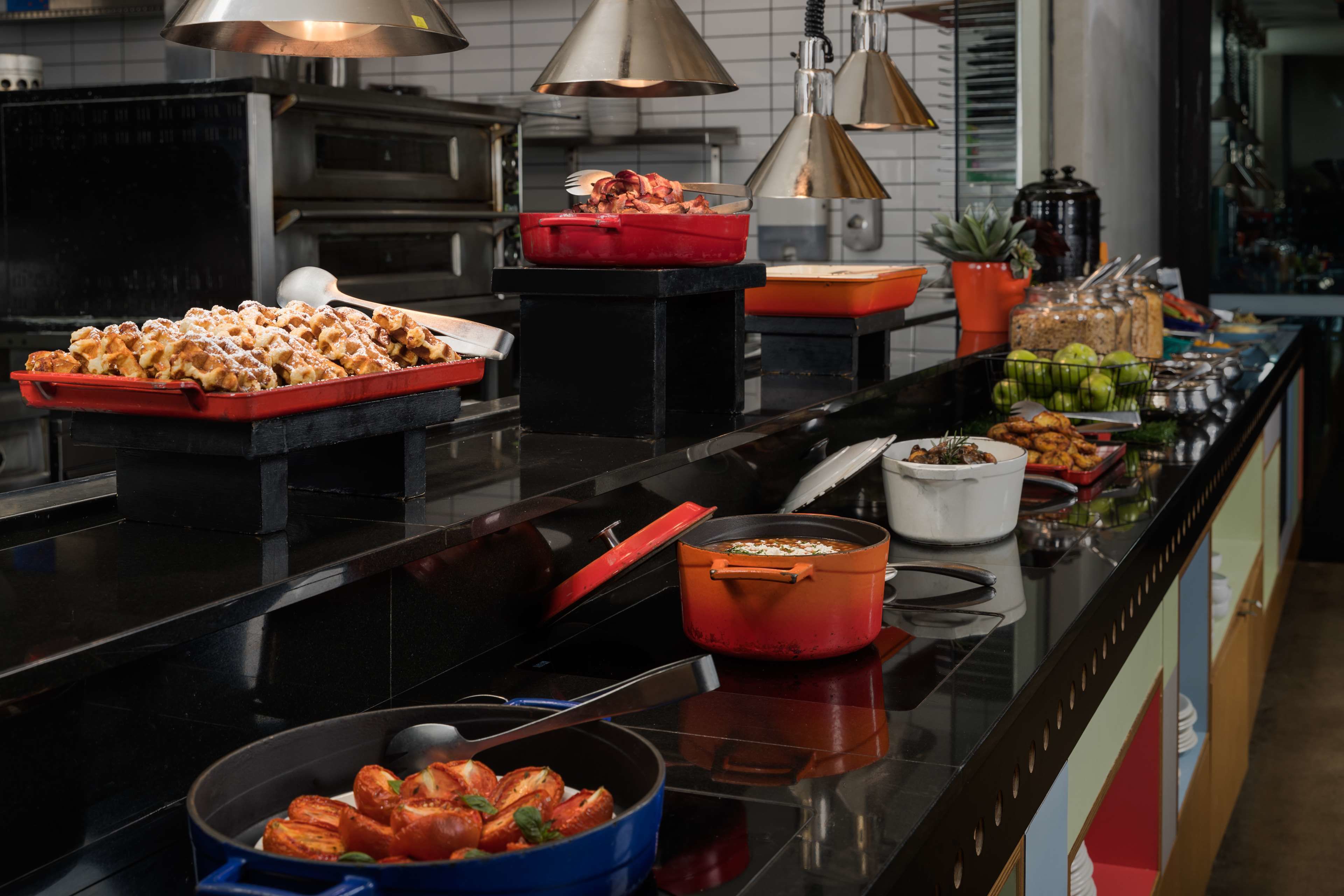 Een buffetopstelling met diverse gerechten en kookattrezzet.
