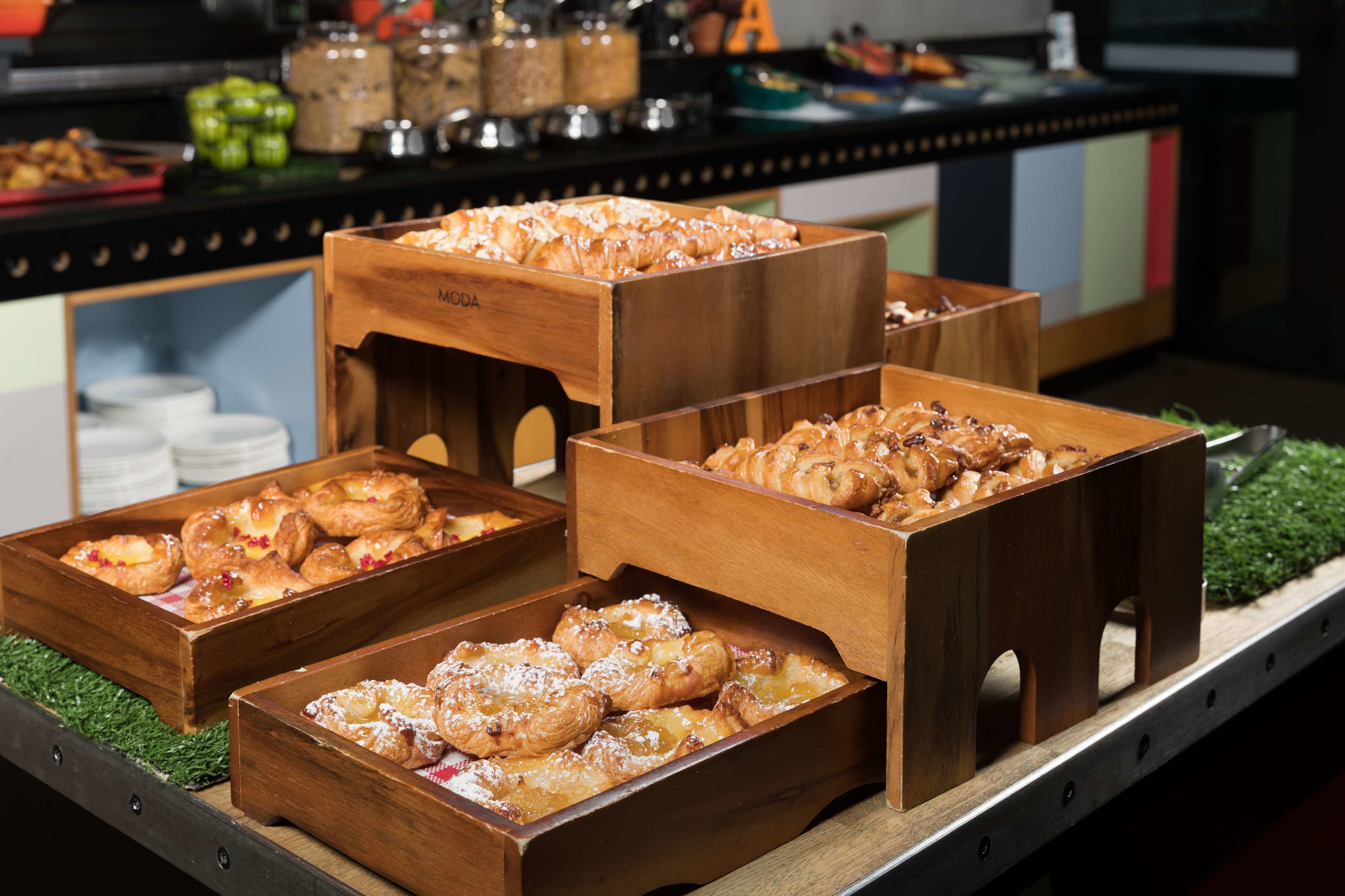 Wooden display cases filled with pastries on a buffet table.