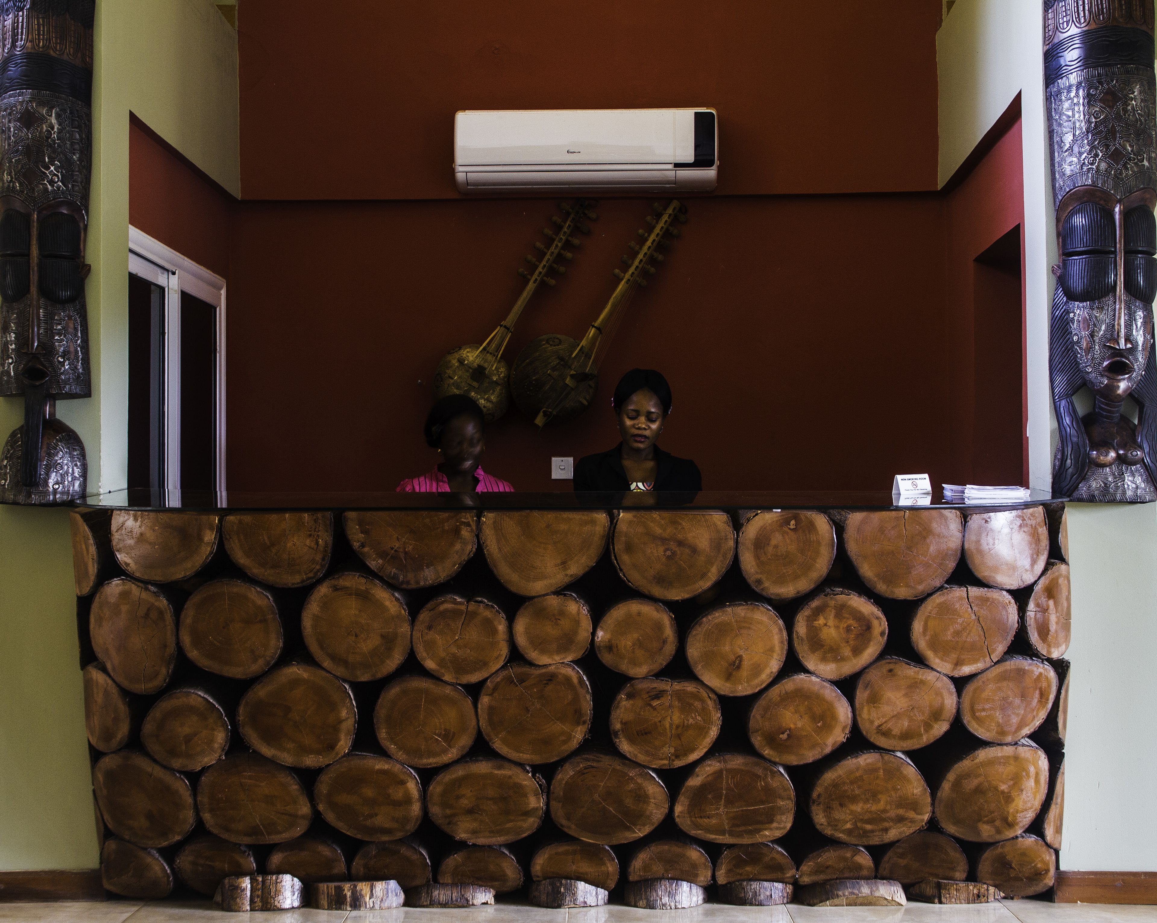 Un área de recepción con una pared de leña apilada, un equipo de aire acondicionado blanco y decoración en la pared.