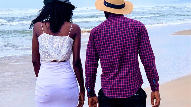 A couple walking on a beach with the ocean in the background. - Bojo Beach Resort (Bortianor)