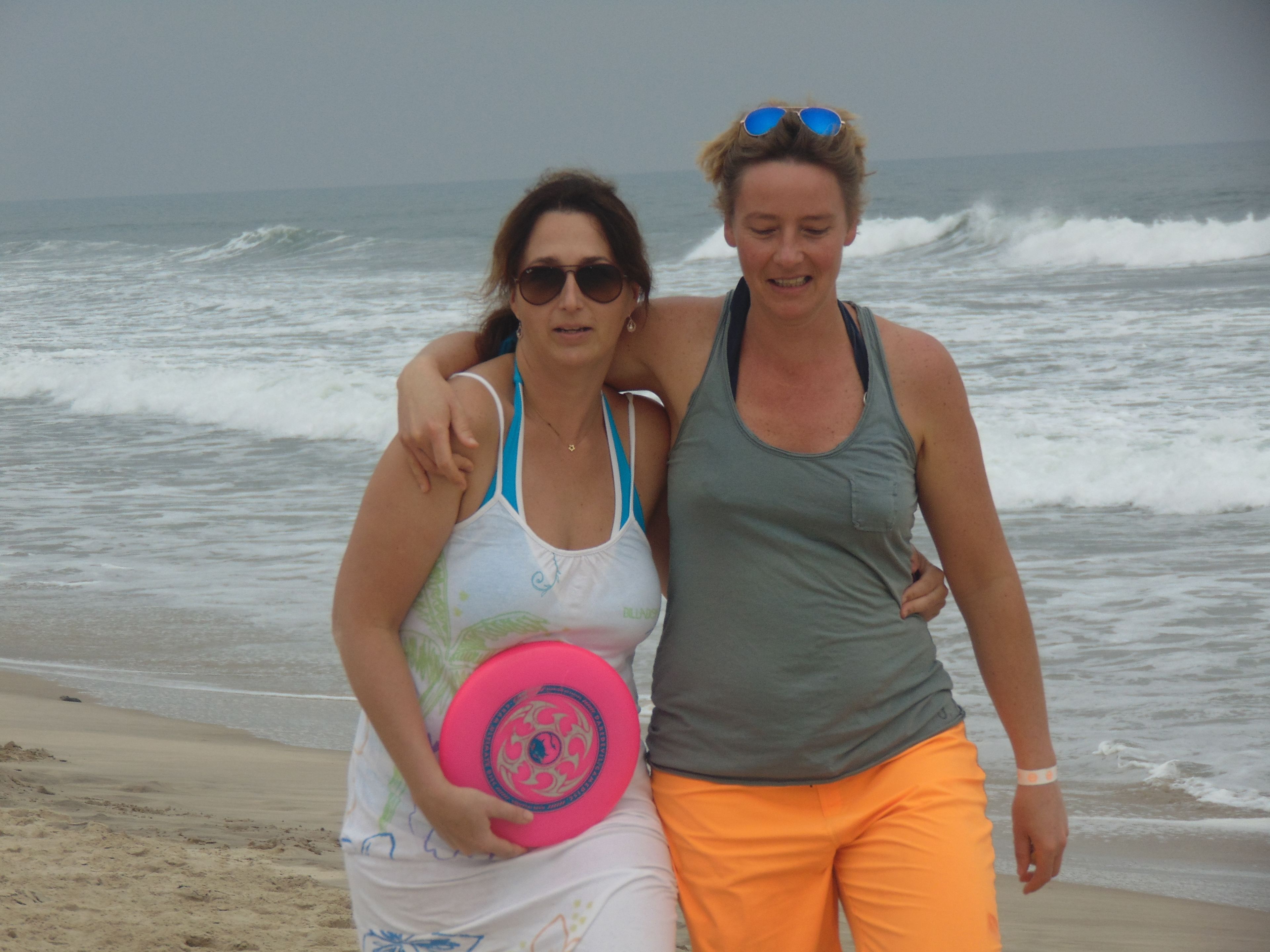 Two people on a beach holding a frisbee.