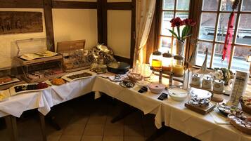 Un bufé de desayuno con diversas opciones de comida y bebidas, una vista decorativa a la ventana y una decoración de estilo rústico.