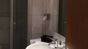 A modern bathroom with a shower, a sink, and a mirror.