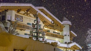 A hotel with a snow-covered exterior, wooden balconies, and a sign indicating it is a hotel. - Pineta Pastry Hotel (Rocca Pietore)