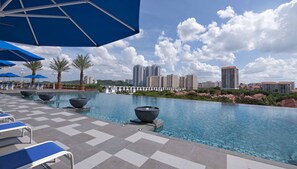 A pool area with lounge chairs and umbrellas, surrounded by high-rise buildings. - Royale Chulan Damansara (Petaling Jaya)