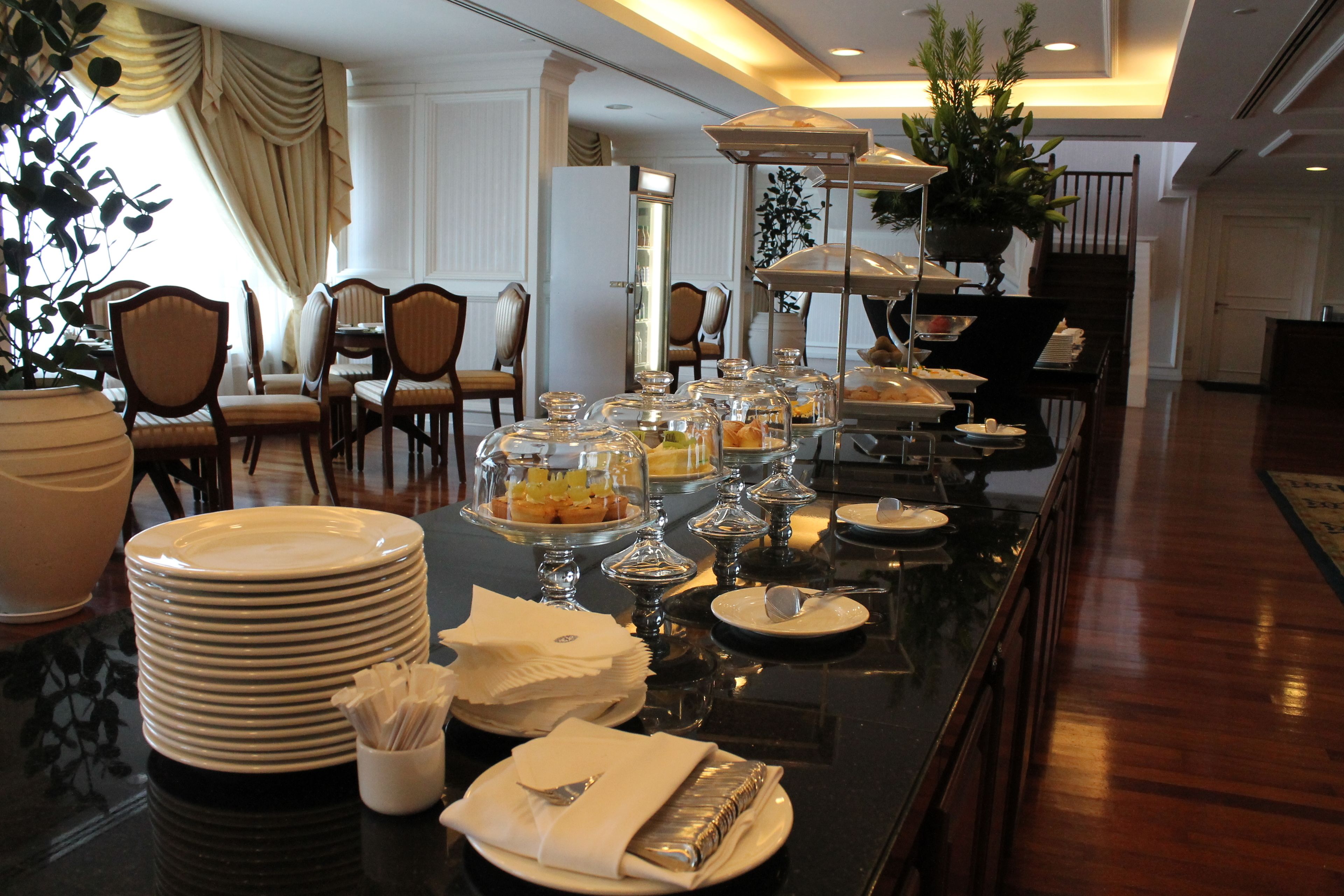 Un buffet avec plusieurs points de service, des assiettes et de la verrerie.