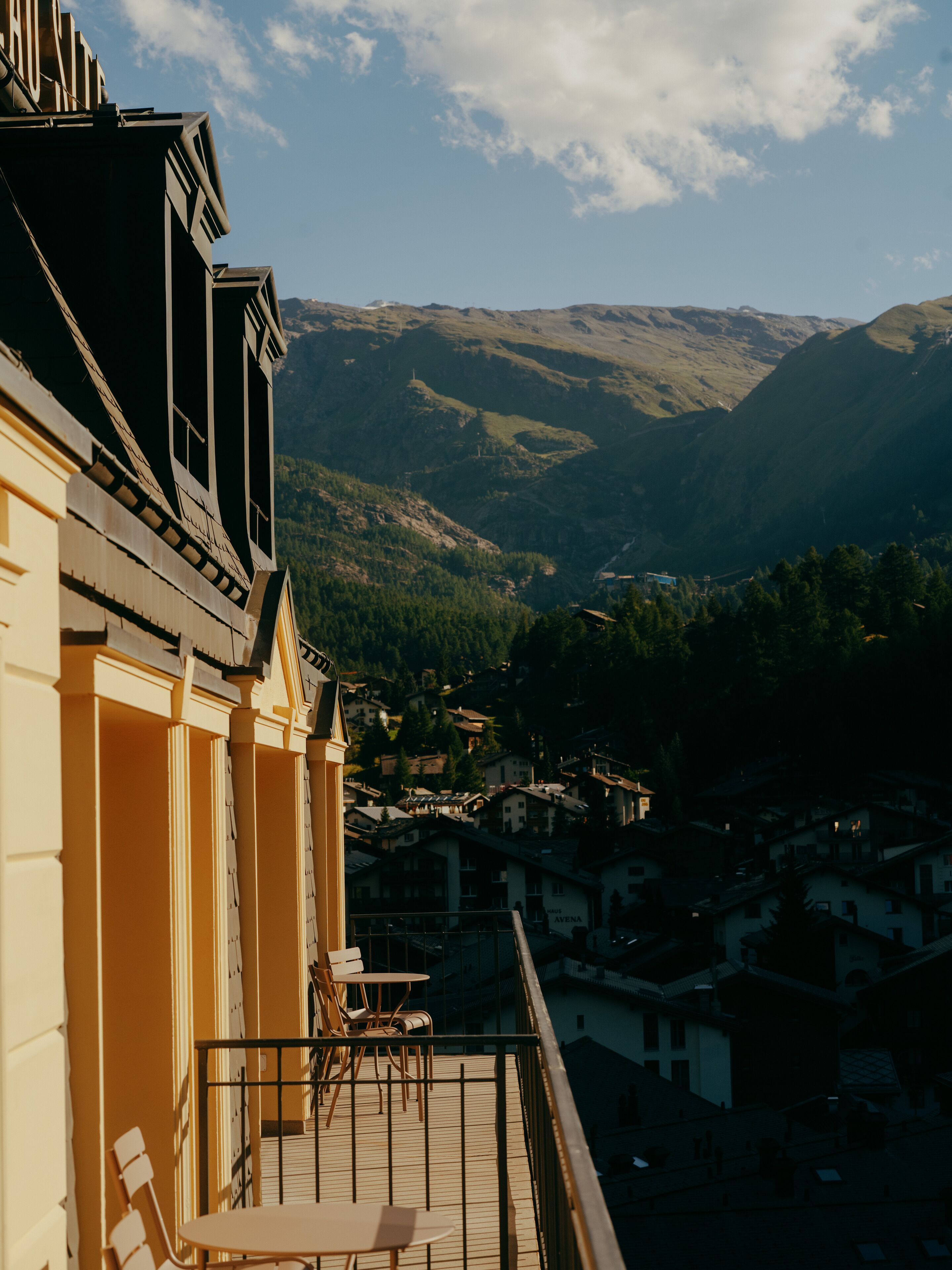 A balcony with a view of a valley and mountains.