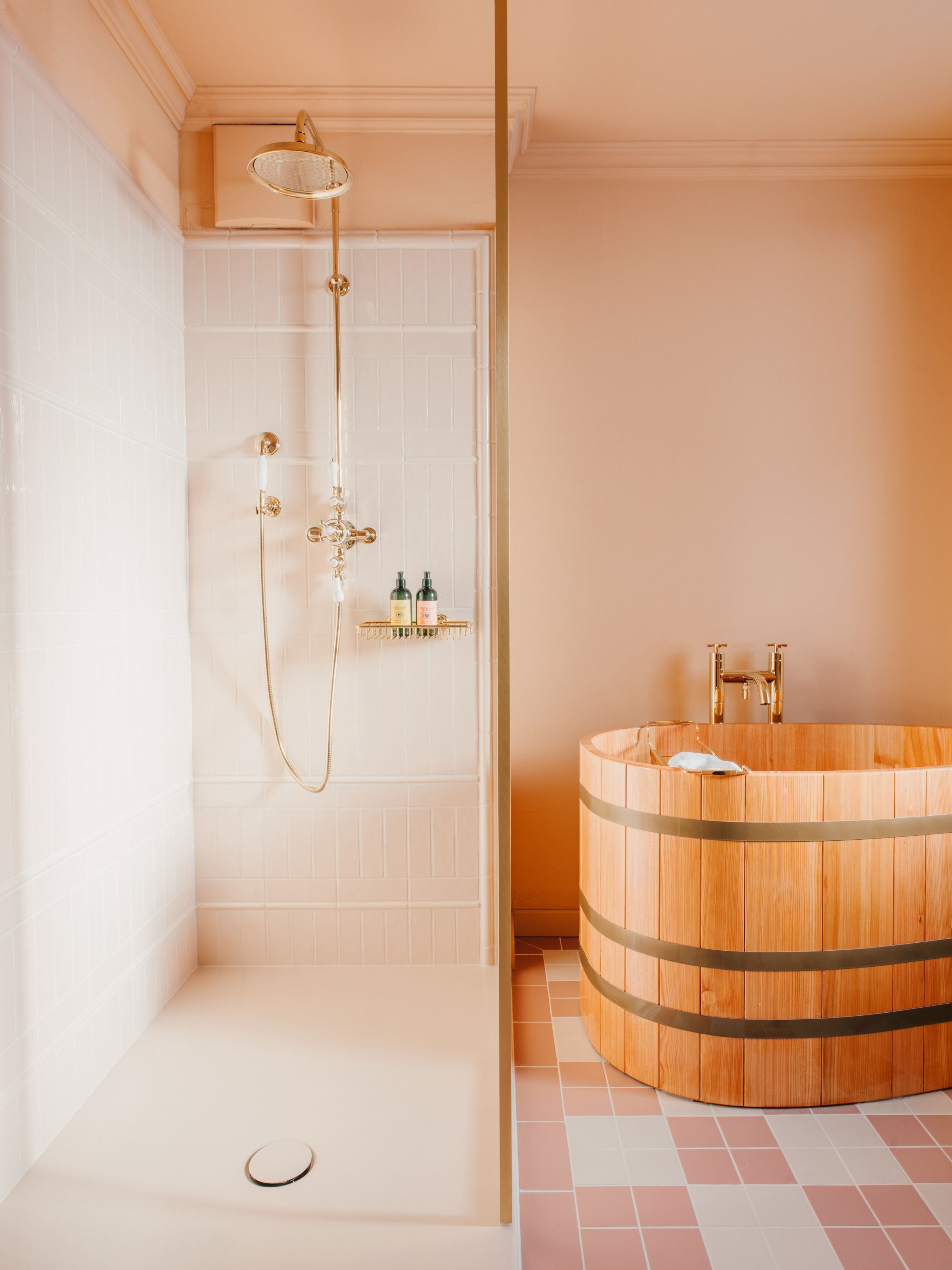 Een moderne badkamer met een inloopdouche, een houten badkuip en een klein plankje met toiletartikelen.