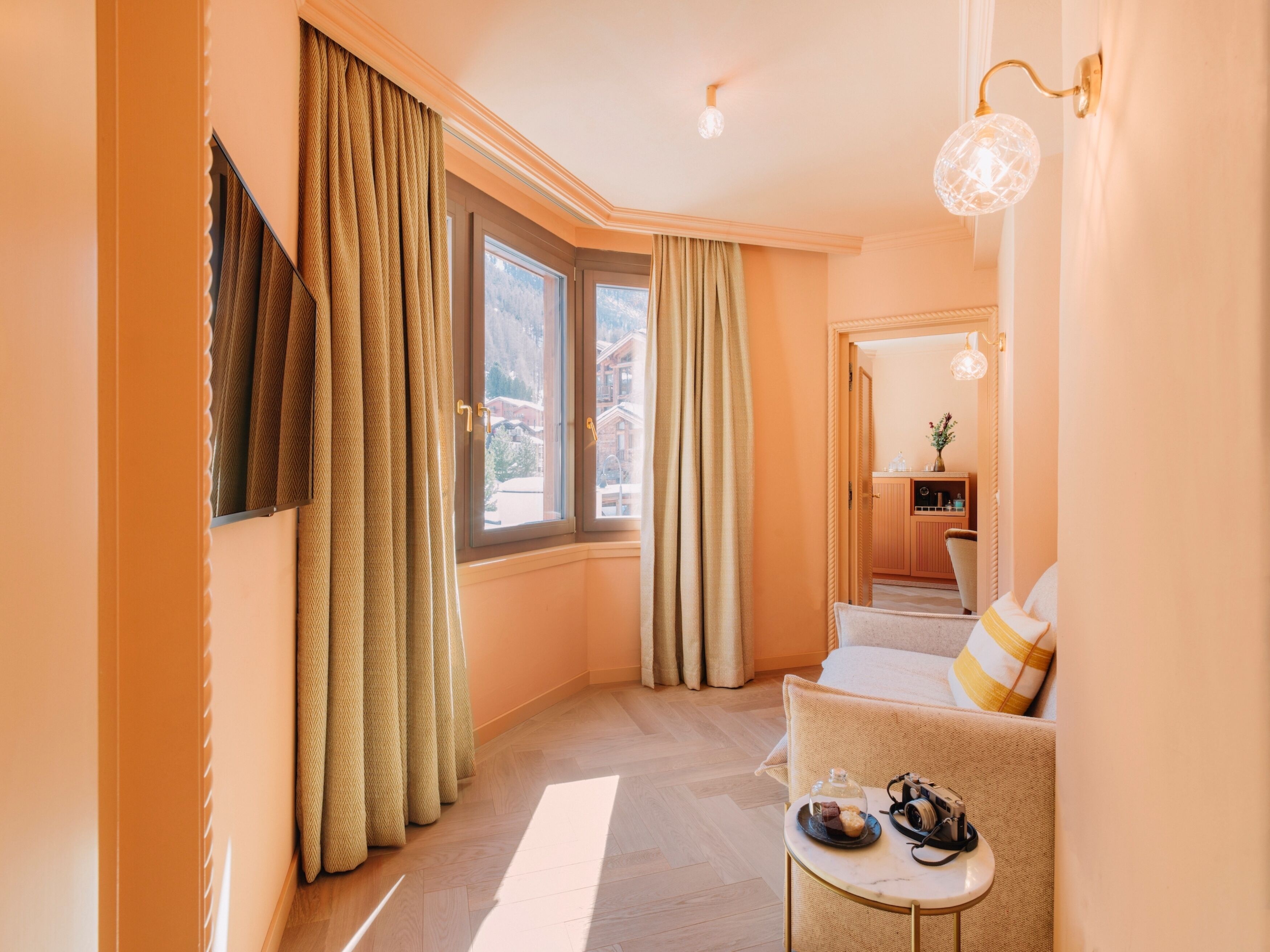 Une chambre d’hôtel avec un lit, une petite table avec une lampe, une chaise et une vue sur l’extérieur par la fenêtre.