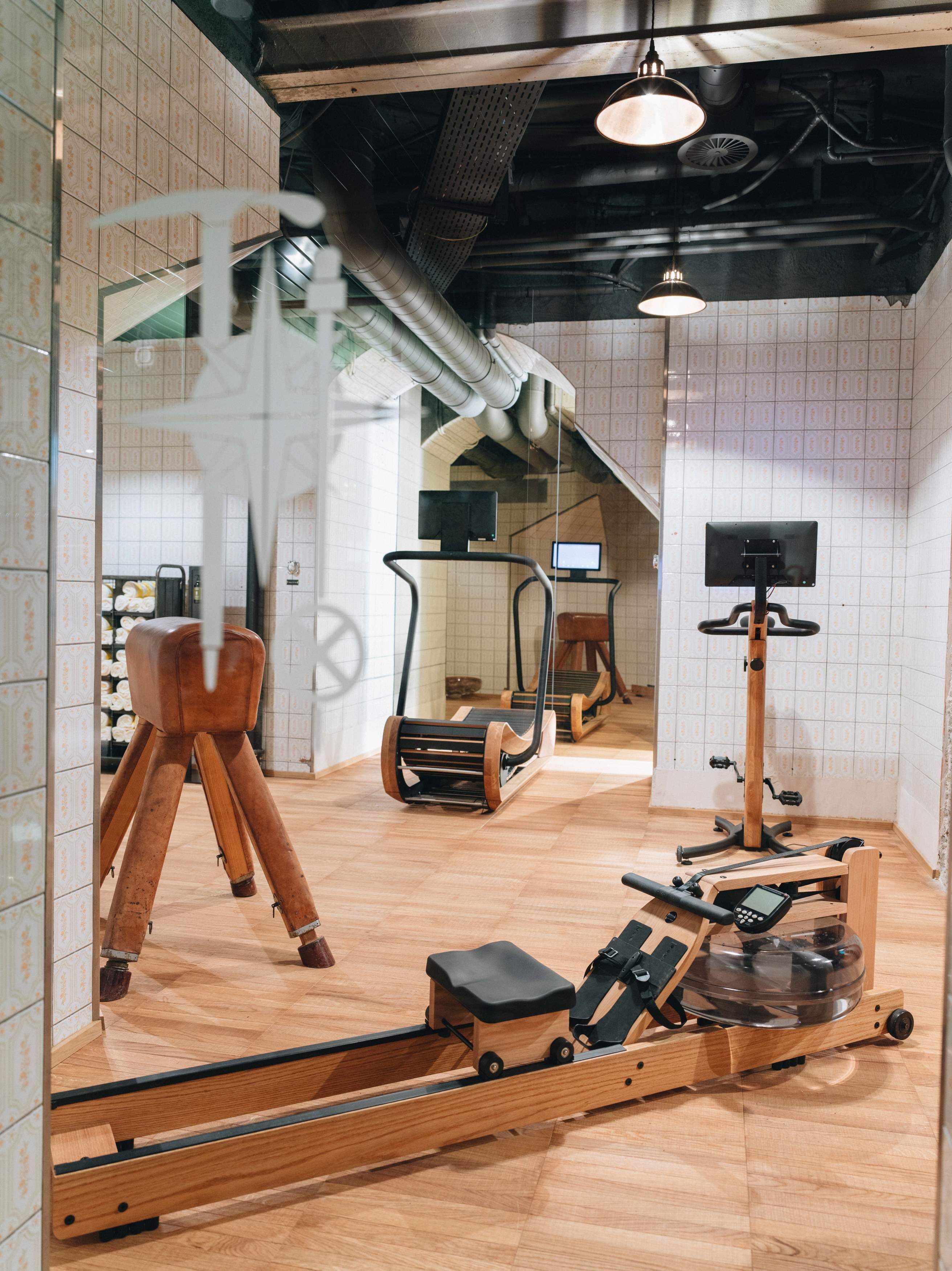 A gym with exercise equipment, including a rowing machine, a stationary bike, and a treadmill.