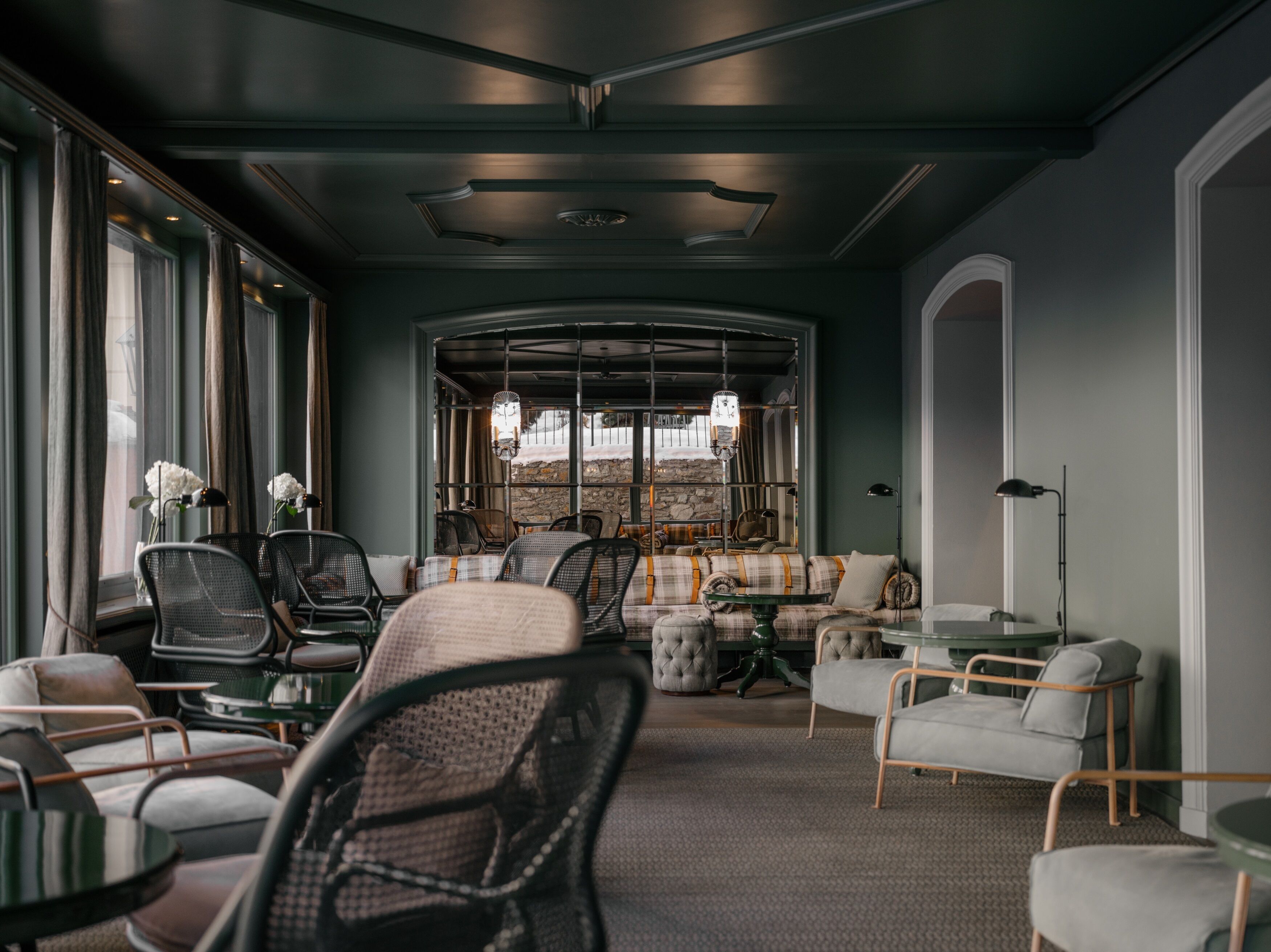 A modern interior with seating arrangements, a fireplace, and large windows.