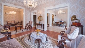 Un salón espacioso con una imponente araña, muebles elegantes y un diseño clásico.