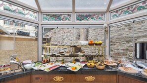 Montaje de bufé con diferentes alimentos y un fondo de pared de piedra.