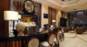 A hotel lobby with a bar area, seating, and a large window. - Babylon Hotel (Dongguan)