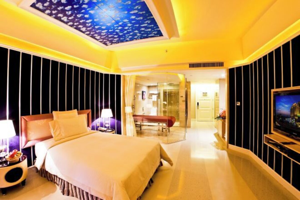 Ein Hotelzimmer mit einem großen Bett, einem Fernseher und einer Fischdecke.