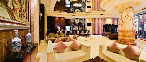 Un vestíbulo amplio con zonas de estar, un bar y una gran fuente decorativa.