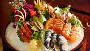 A sushi platter with various types of fish and garnishes. - Babylon Hotel (Dongguan)