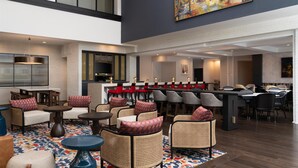 A spacious lobby with high ceilings, a central bar area, and comfortable seating arrangements. - Hilton Garden Inn Charleston Waterfront/Downtown (Charleston)
