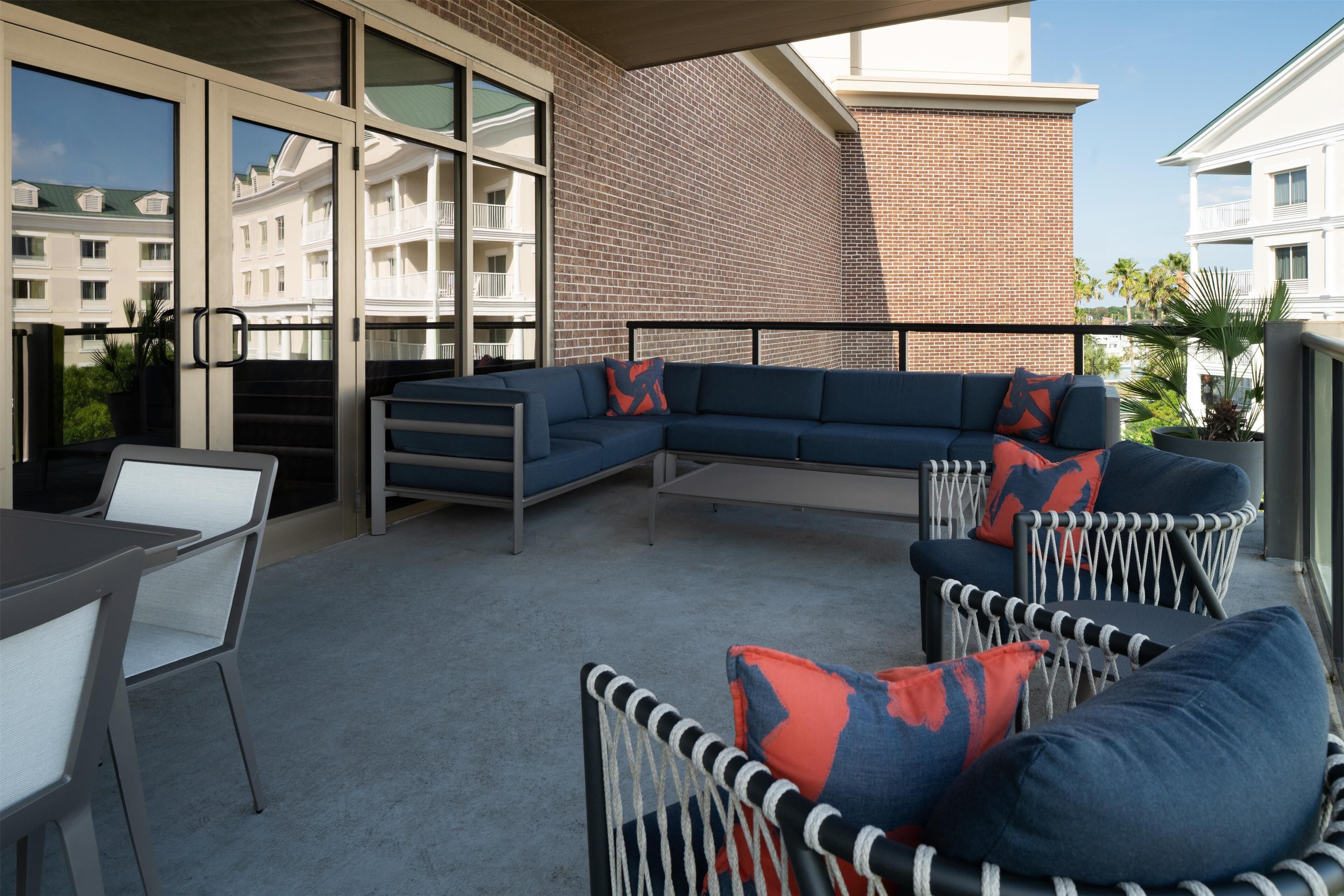 A modern outdoor seating area with a sectional sofa, chairs, and a table.
