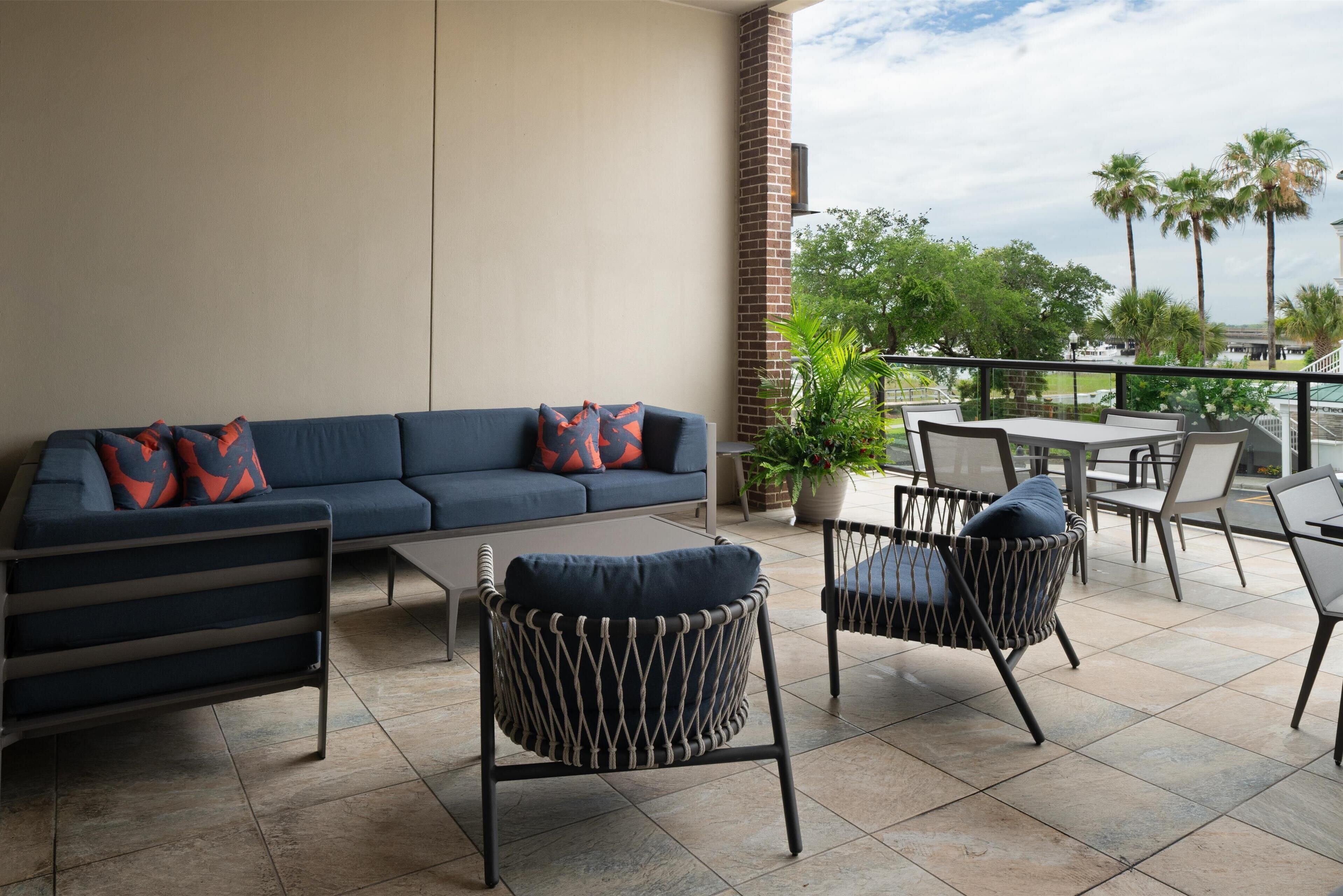Une terrasse avec un canapé, des chaises et une table.