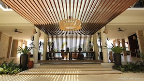 A covered entrance with vertical wooden slats, a central hanging light fixture, and potted plants.