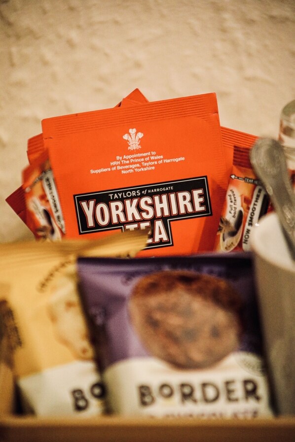 A stack of red packets labeled "Yorkshire Tea" and a box of "Border" biscuits.