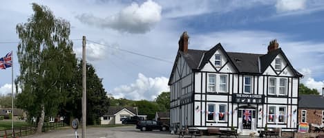 Un bâtiment traditionnel aux couleurs noir et blanc, sur lequel on peut lire l’inscription : « The Ham & Cheese ».