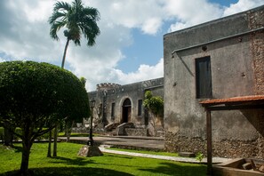 Un bâtiment historique doté d’une cour, de palmiers et surplombant un ciel dégagé.
