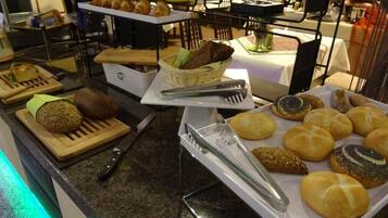 Un buffet proposant une variété de pains et de viennoiseries.