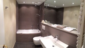 A modern bathroom with a bathtub, toilet, and sink. - Schlosshotel Rettershof (Kelkheim)