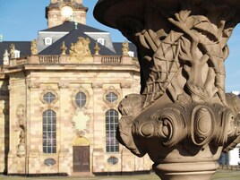 A classical building with ornate stone carvings and a prominent clock tower.