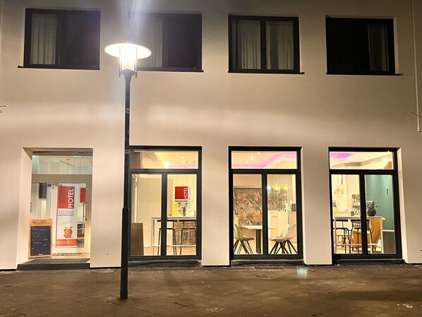 A hotel entrance with a signboard, a street lamp, and a view into the interior. - Hotel Madeleine Saarbrücken City (Saarbrücken)